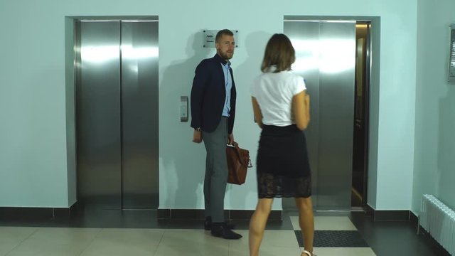 a group of businessmen walks to the Elevator