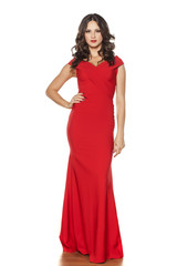 young beautiful woman posing in a long red dress on a white background
