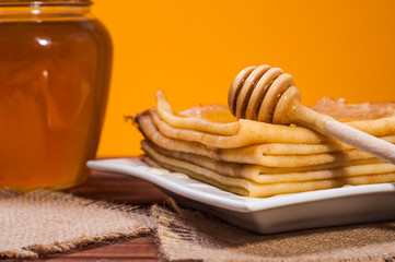 Fresh honey with a Stack of blinis or crepes