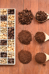 different coffee forms in wooden box and ground coffee in wooden spoon