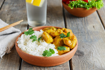 chicken curry with rice on a wooden surface
