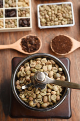 Coffee beans with coffee grinder and ground coffee in wooden spoon 