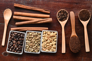 Coffee beans with ground coffee in wooden spoon and cinnamon 