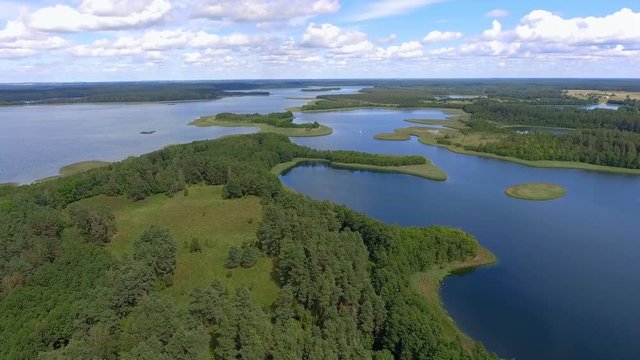 View of small islands on the lake in Masuria and Podlasie district, Poland. Blue water and whites clouds. Summer time. View from above.