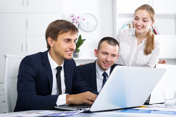 Three young coworkers working in company office