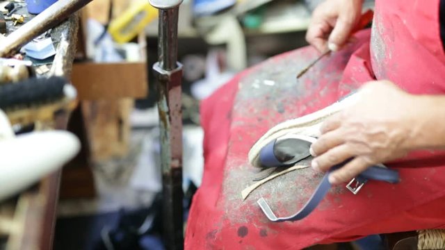 Calzolaio al Lavoro nella sua bottega artigianale. Suola scarpa alta per donna. 