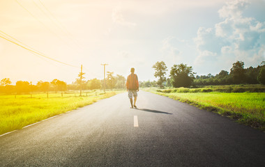 Fototapeta premium Young man walking on the countryside road.