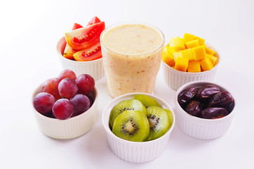 Close up of healthy glass of mixed fruits smoothie with fruits on white background.