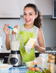Woman with blender at kitchen.