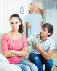 Relatives quarrelling with young woman in domestic interior
