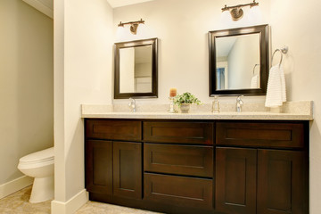Bathroom interior in white tones with black vanity cabinet.
