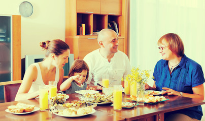 Obraz na płótnie Canvas multigeneration family eating fish with vegetables