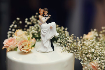 Funny figurines suite at a luxury wedding white cake