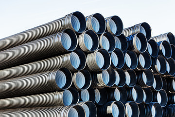 stacks of black pvc plastic pipe outdoors