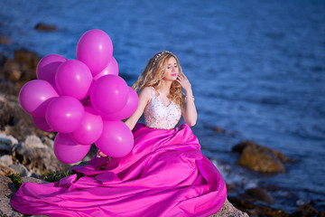 Fototapeta na wymiar beautiful girl on the beach with balloons