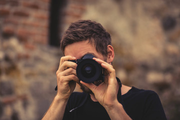 Young men boy close up photographer taking photo with holding digital camera in the nature on the summer sun