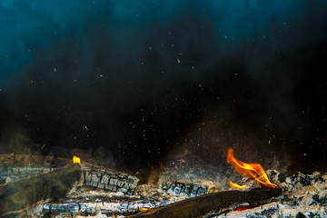 Fire showing piled logs burning in a fire place.