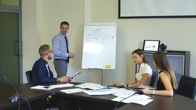 colleagues discussing graphs in the conference room