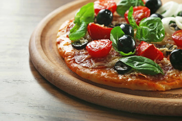Tasty pizza with vegetables, herbs on wooden background