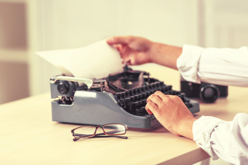 Man working on retro typewriter at desk