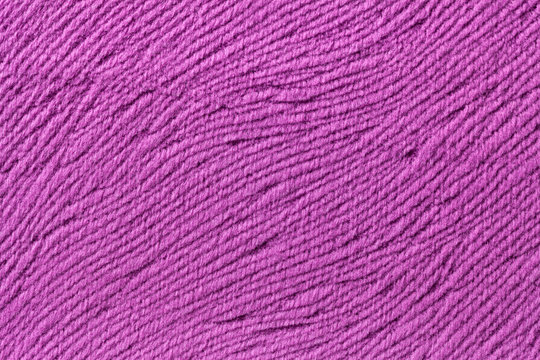 Purple background from soft textile material. Fabric with natural texture.
