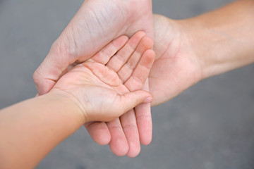 Family hands on gray background