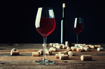 Glass of red wine and corks
