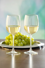 Glasses with white wine and grape on a table