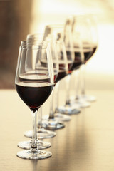 Glasses with red wine in a row on a table