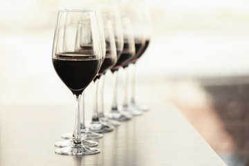 Glasses with red wine in a row on a table