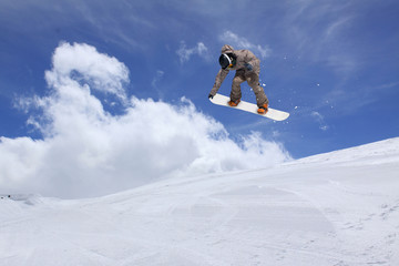 Naklejka na ściany i meble Snowboarder jumping in snowy winter mountains