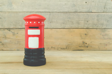 Small red post box on wood background