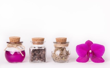 Pink orchid and three glass bottles on a white background. Spa concept. Cosmetic bottles. Ecological natural cosmetics. Copy space.