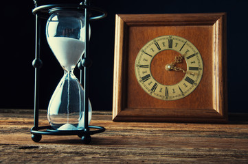 Hourglass and old vintage clock