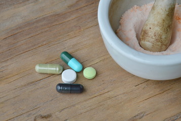 mortar and pestle for crushed pill on wooden board