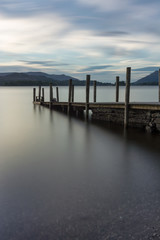 Obraz premium Wooden Jetty with poles leading into Derwentwater Lake in the Lake District, UK.