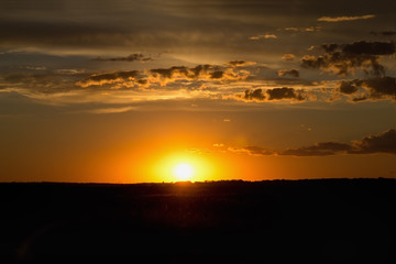 Fototapeta na wymiar Beautiful cloudy sunset in the field