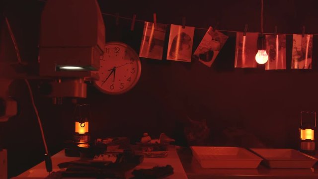 Photography darkroom with black and white drying pictures red safelight equipment and reagents