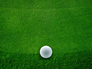 Green grass background on a golf course with golf ball. Golf club concept.