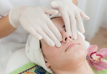 Facial massage,beautician makes facial massage ,skin treatment to a beautiful young girl