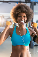 Fototapeta na wymiar Happy healthy young African American woman working out in a gym