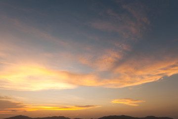 Dramatic sunset sky with orange and blue colored clouds.