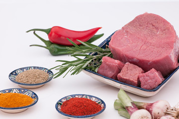 raw meat with spices and onions on a white background