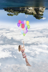 Girl hanging by a bunch of balloons flying toward a world upside down, in the below there is the earth, at the top there is an island in the sea