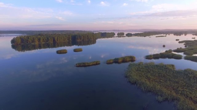 Sunrise at summer time lake and green forest, sand and reflection in water, Poland lanscape. View from above.