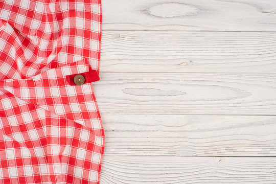 red folded tablecloth over bleached wooden table.