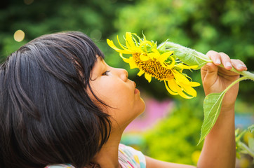 cute child with sunflower in nature