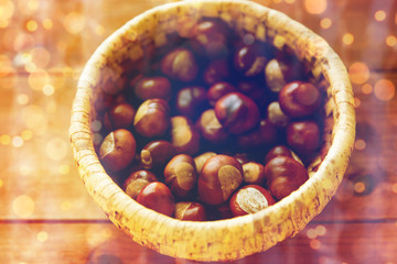 close up of chestnuts in basket on wooden table