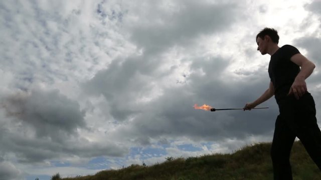 The fire eater, spitting fire.