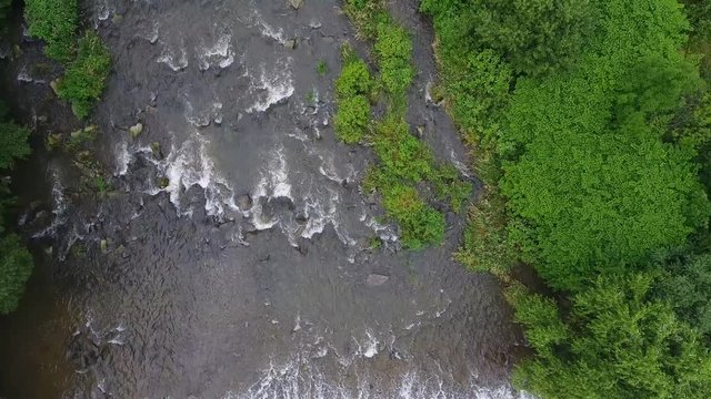 Mountain river and green riverbank from above.